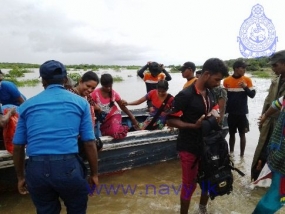 Navy assists civilians to cross flooded bridge at Mandagal Aru